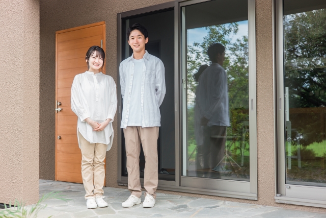 一軒家の前に立つ夫婦