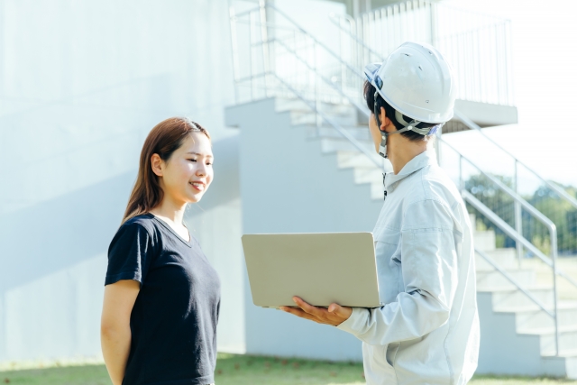 説明する作業着の男性